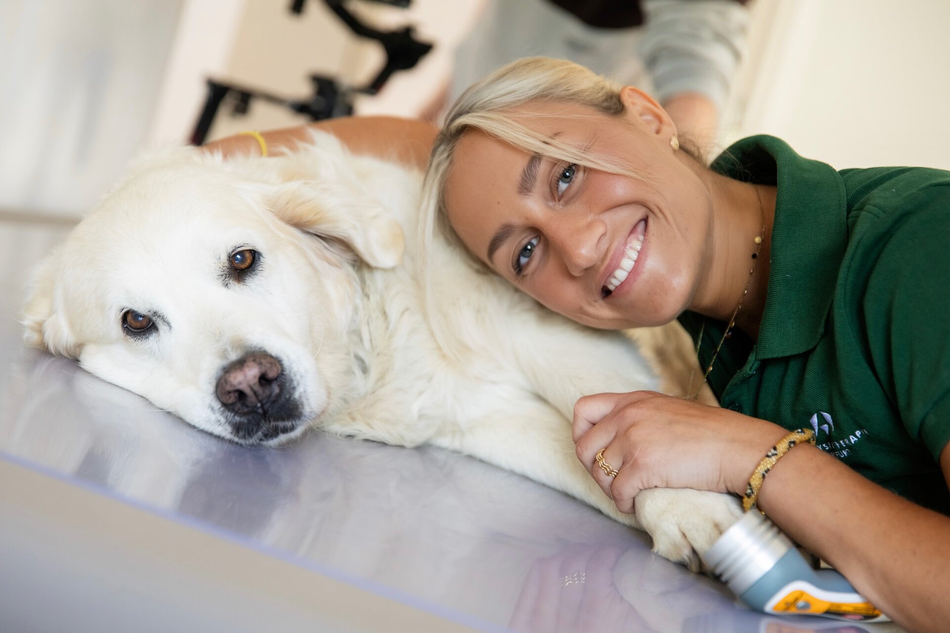 Josephine Kunschert liegt mit ihrem Hund entspannt auf der Behandlungsliege